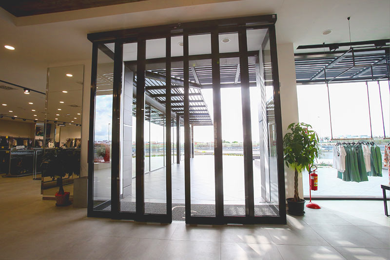 Compacte aandrijving boven een automatische glazen schuifdeur